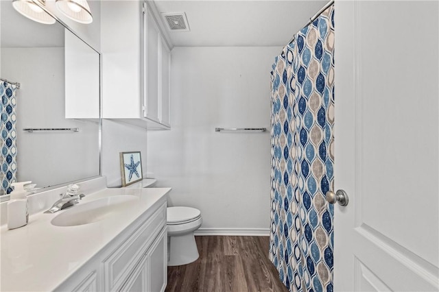 bathroom featuring hardwood / wood-style floors, vanity, toilet, and walk in shower