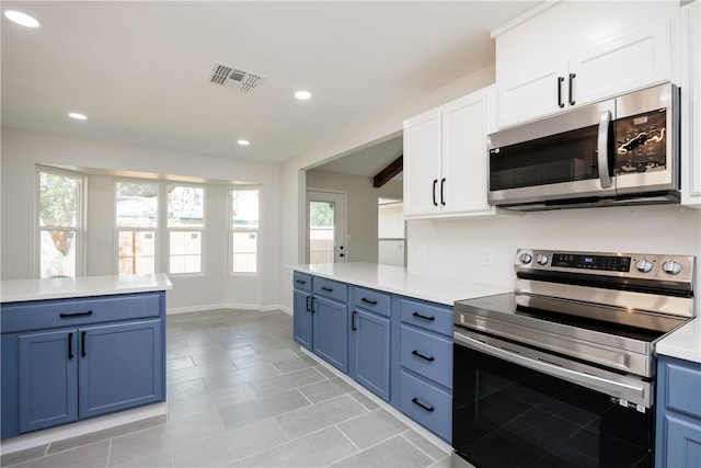 kitchen with blue cabinetry, appliances with stainless steel finishes, and white cabinets