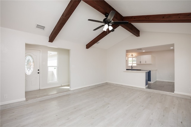 unfurnished living room with lofted ceiling with beams, light hardwood / wood-style floors, and ceiling fan