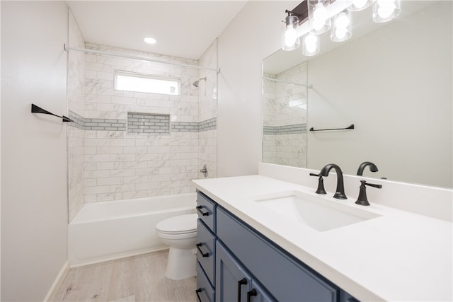 full bathroom with hardwood / wood-style floors, vanity, toilet, and tiled shower / bath