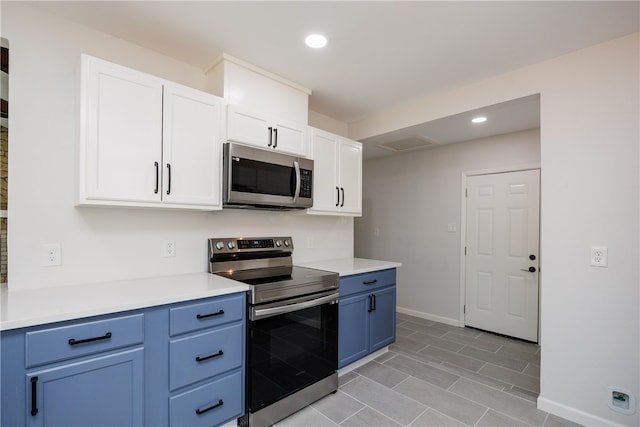 kitchen with white cabinetry, stainless steel appliances, and blue cabinetry