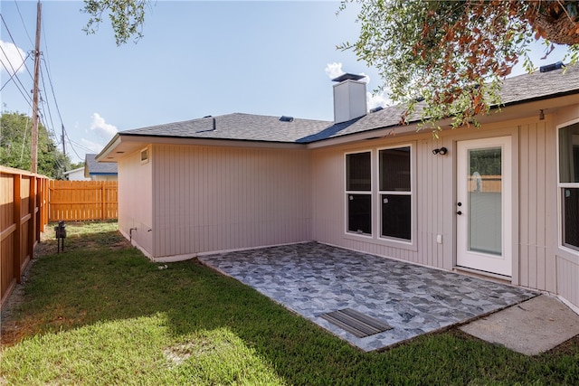 rear view of property with a patio and a yard