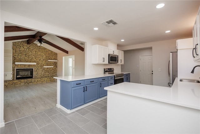 kitchen with white cabinets, kitchen peninsula, light hardwood / wood-style flooring, sink, and appliances with stainless steel finishes