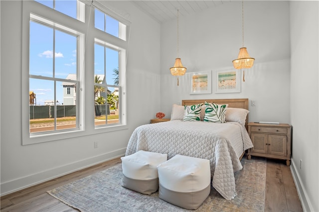 bedroom with hardwood / wood-style flooring and a notable chandelier