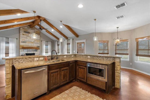 kitchen with appliances with stainless steel finishes, visible vents, a sink, and lofted ceiling with beams