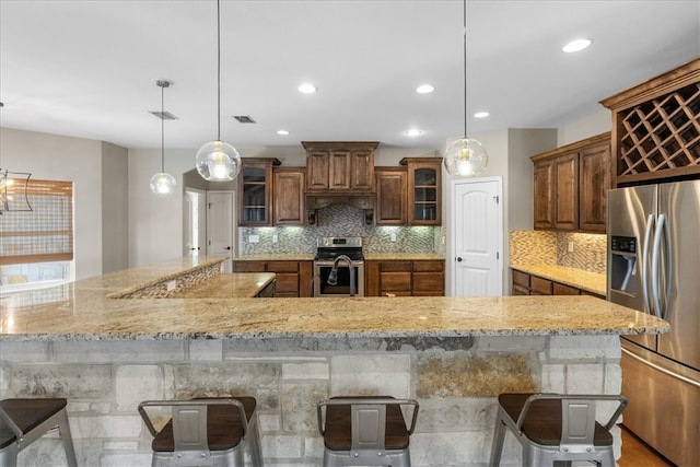 kitchen with glass insert cabinets, visible vents, appliances with stainless steel finishes, and backsplash