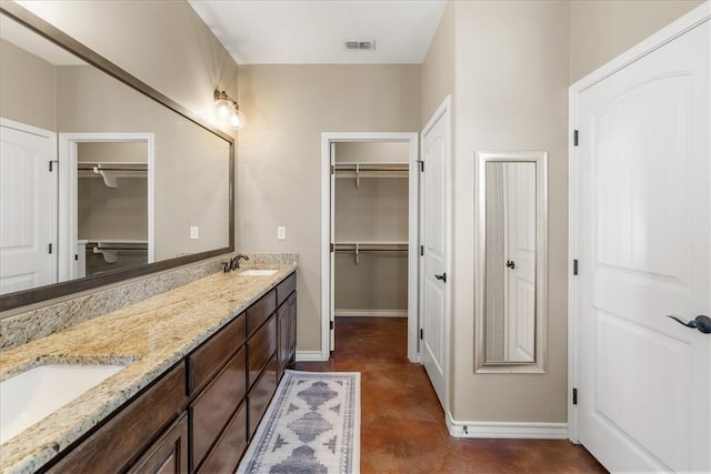 full bath featuring double vanity, a sink, visible vents, and finished concrete floors