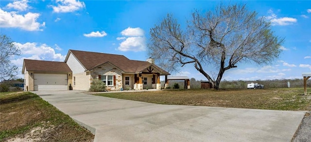 view of front of property with driveway, stone siding, a garage, and a front yard