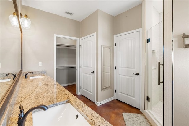 bathroom with double vanity, a shower stall, visible vents, and a sink