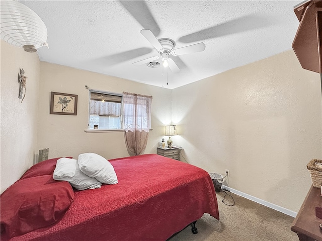 bedroom featuring a textured ceiling, ceiling fan, and light carpet