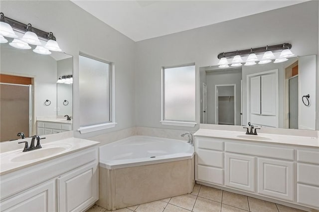 bathroom featuring a sink, tile patterned flooring, a stall shower, and a garden tub