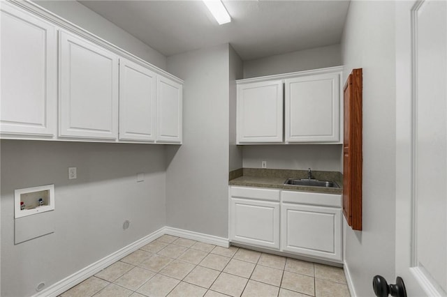 laundry area featuring washer hookup, cabinet space, a sink, baseboards, and light tile patterned flooring