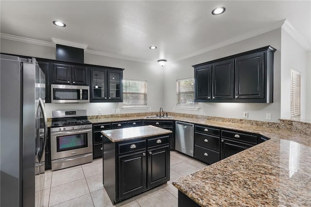 kitchen with ornamental molding, a center island, dark cabinetry, a sink, and stainless steel appliances