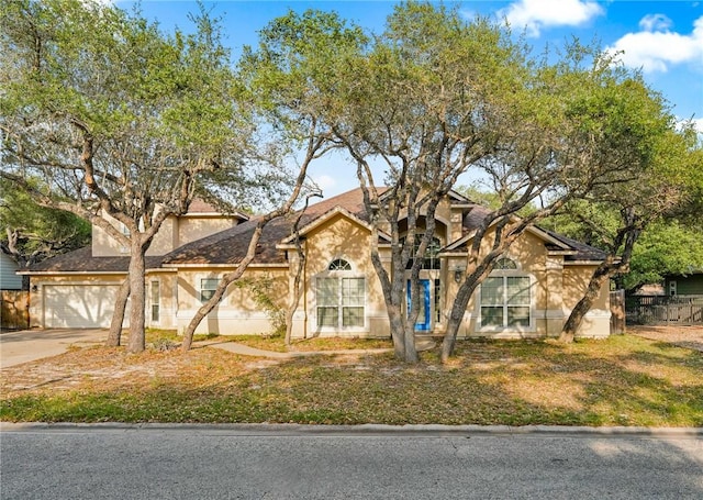 view of front of home with a garage, stucco siding, and concrete driveway