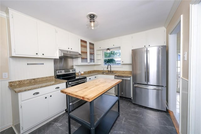 909 Cunningham St, Corpus Christi, TX 78411 - kitchen with appliances with stainless steel finishes, a sink, under cabinet range hood, dark marble finish flooring, and white cabinetry