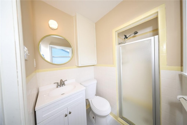 909 Cunningham St, Corpus Christi, TX 78411 - bathroom featuring tile walls, a shower stall, vanity, toilet, and a wainscoted wall