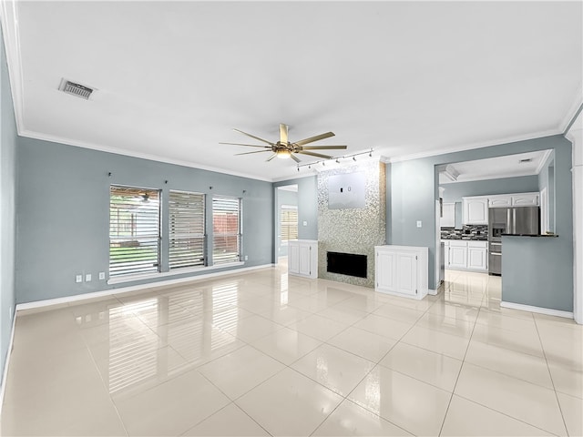 unfurnished living room with ceiling fan, a large fireplace, light tile patterned floors, and ornamental molding