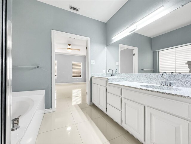 bathroom with tile patterned floors, vanity, ceiling fan, and a bathtub