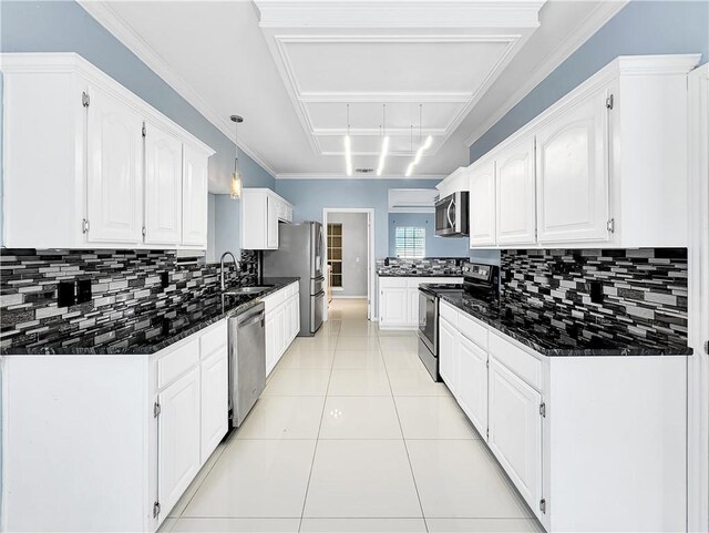 kitchen with appliances with stainless steel finishes, light tile patterned floors, pendant lighting, dark stone countertops, and white cabinets