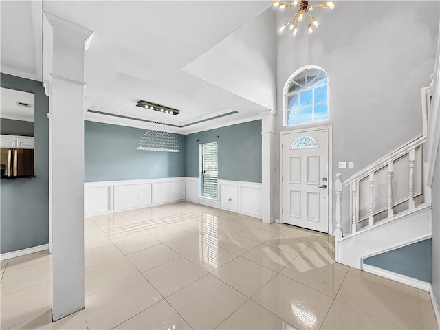 foyer entrance with light tile patterned floors, ornate columns, and a wealth of natural light