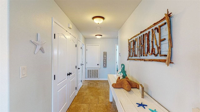 hall featuring light tile patterned floors