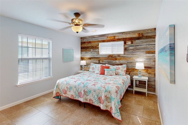 bedroom featuring ceiling fan and wooden walls