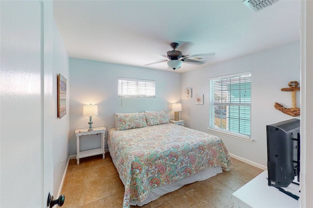 tiled bedroom featuring ceiling fan