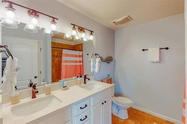 bathroom featuring vanity, tile patterned floors, toilet, and walk in shower