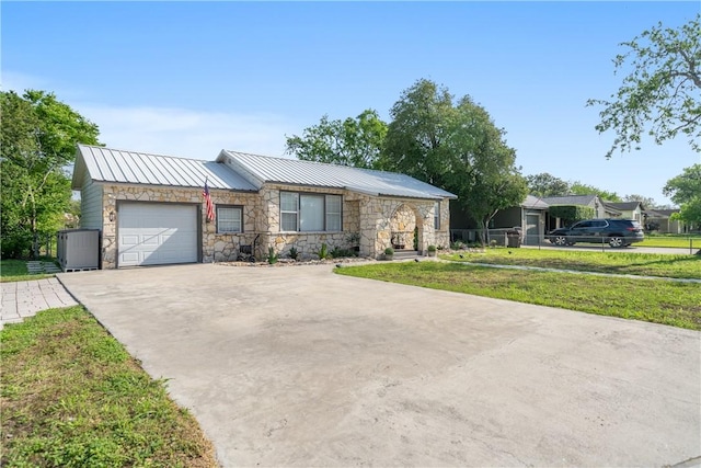 view of front of home featuring stone siding, concrete driveway, a garage, and metal roof