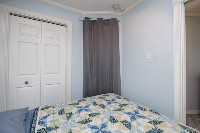 bedroom with crown molding, baseboards, and a closet