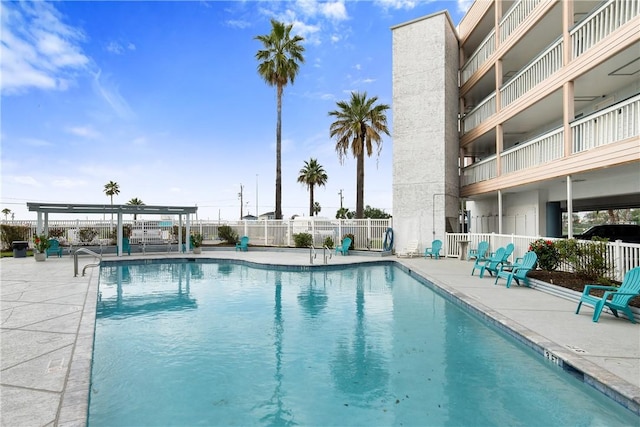 community pool with fence, a patio, and a pergola