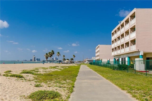 view of community featuring a water view and fence