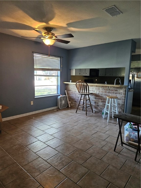 dining area with ceiling fan and sink