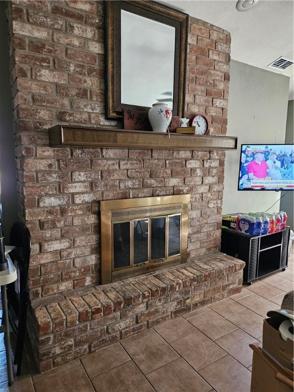 interior details featuring a textured ceiling, tile patterned flooring, and a fireplace