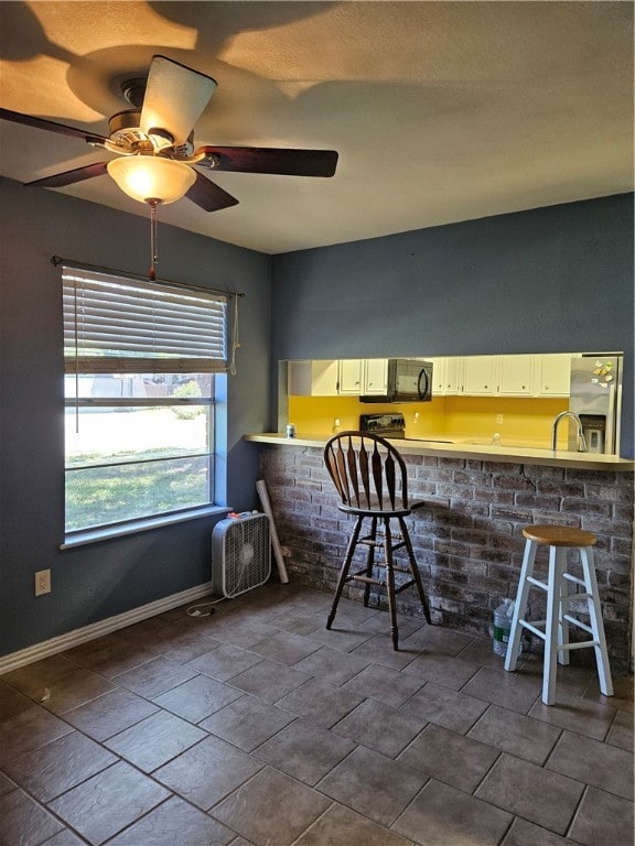 interior space featuring ceiling fan and sink