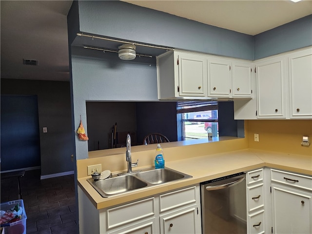 kitchen with dishwasher, dark tile patterned flooring, sink, and white cabinets