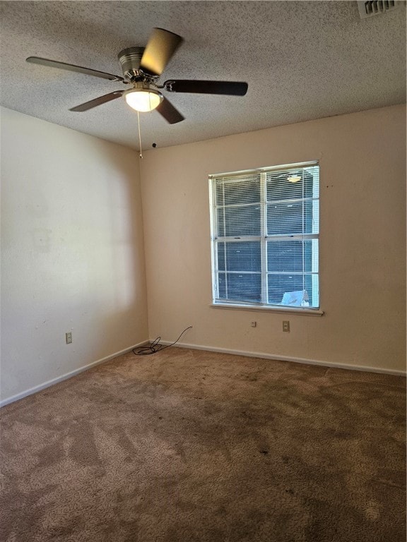 carpeted spare room featuring ceiling fan and a textured ceiling