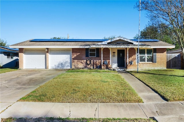 ranch-style house featuring solar panels, a garage, and a front lawn