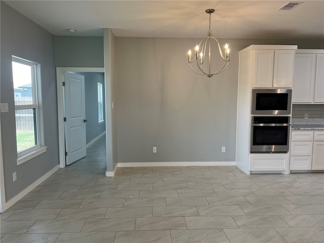 kitchen with white cabinetry, backsplash, a healthy amount of sunlight, and stainless steel appliances