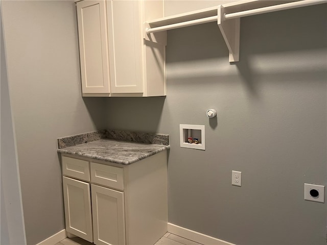 washroom with cabinets, washer hookup, light tile patterned floors, and hookup for an electric dryer