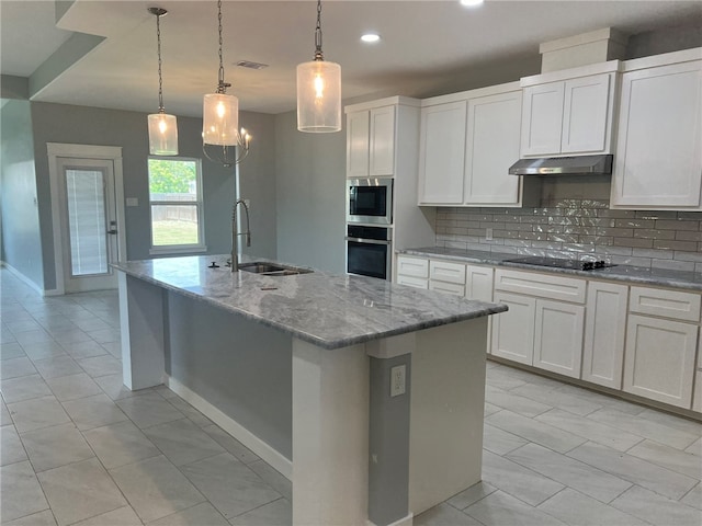 kitchen with sink, an island with sink, decorative light fixtures, white cabinets, and appliances with stainless steel finishes