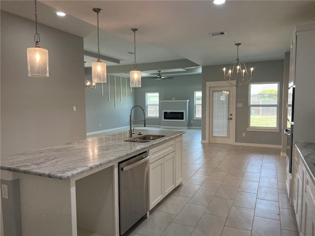 kitchen with appliances with stainless steel finishes, sink, a center island with sink, white cabinets, and hanging light fixtures