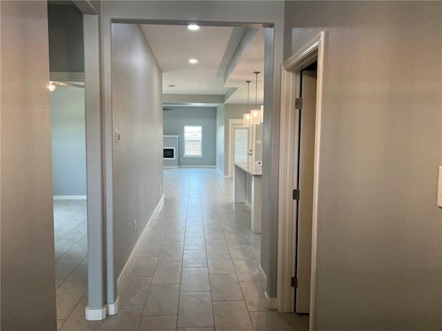 corridor featuring a notable chandelier and light tile patterned flooring