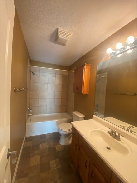 full bathroom featuring vanity, a textured ceiling, toilet, and tiled shower / bath