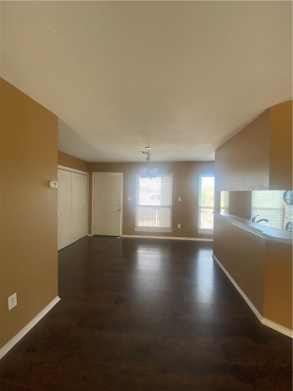 unfurnished room with dark hardwood / wood-style flooring and a notable chandelier