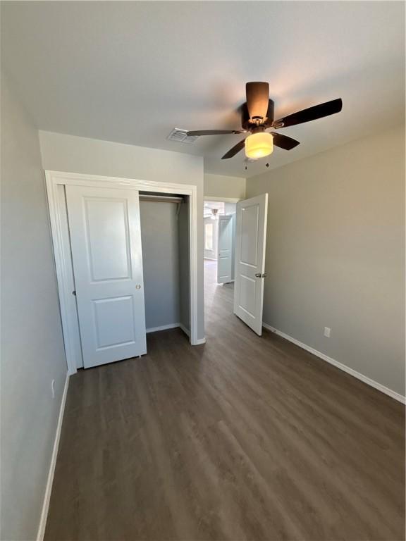 110 Josephine St, Corpus Christi, TX 78401 - unfurnished bedroom with baseboards, a closet, dark wood-type flooring, and a ceiling fan