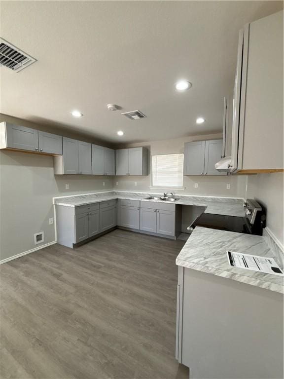 110 Josephine St, Corpus Christi, TX 78401 - kitchen with gray cabinets, electric stove, a sink, wood finished floors, and recessed lighting