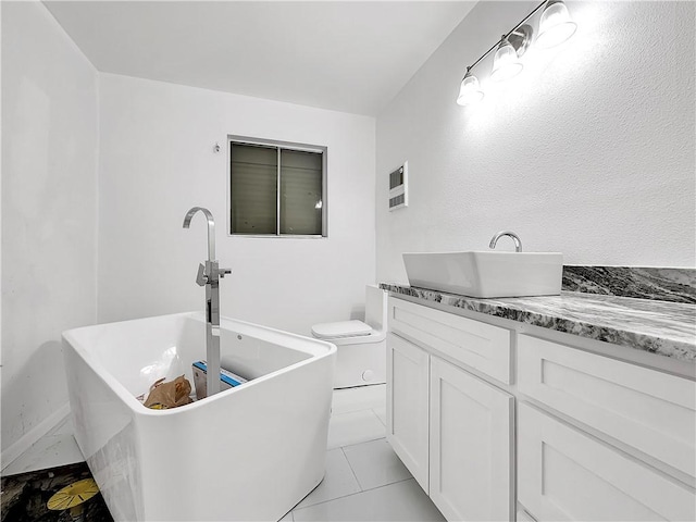 full bath featuring toilet, a freestanding tub, and vanity