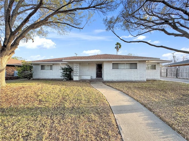 single story home featuring brick siding, a front lawn, and fence