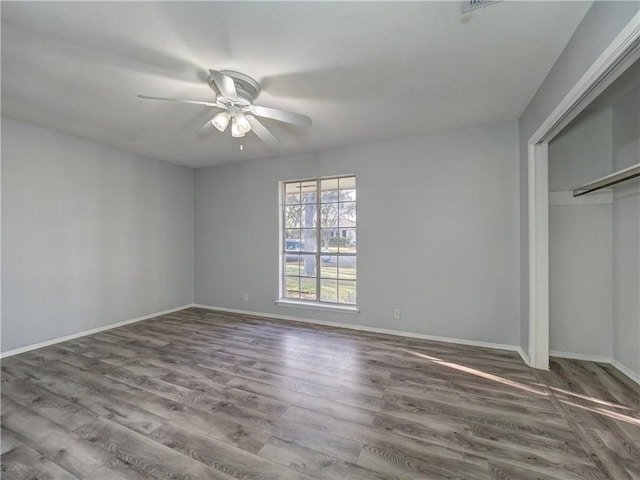 unfurnished bedroom featuring hardwood / wood-style floors, a closet, and ceiling fan